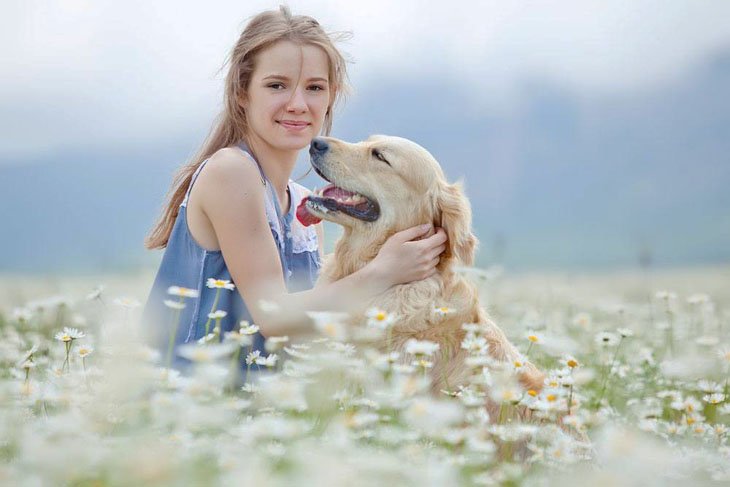 Pretty girl with her dog in a field
